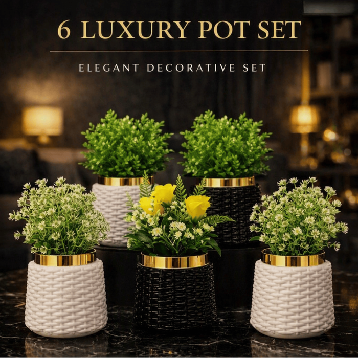 Six luxury decorative potted plants arranged on a dark marble surface in a warmly lit interior setting. The set includes three woven white pots with yellow flowers, two black woven pots with green foliage, and two black pots with white flowers and greenery.